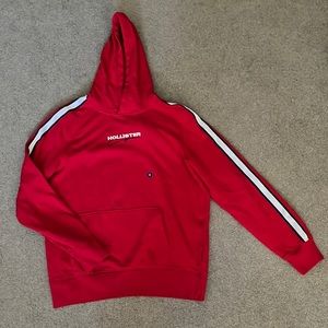 Hollister red sweatshirt hoodie with black and white stripes on the sleeves